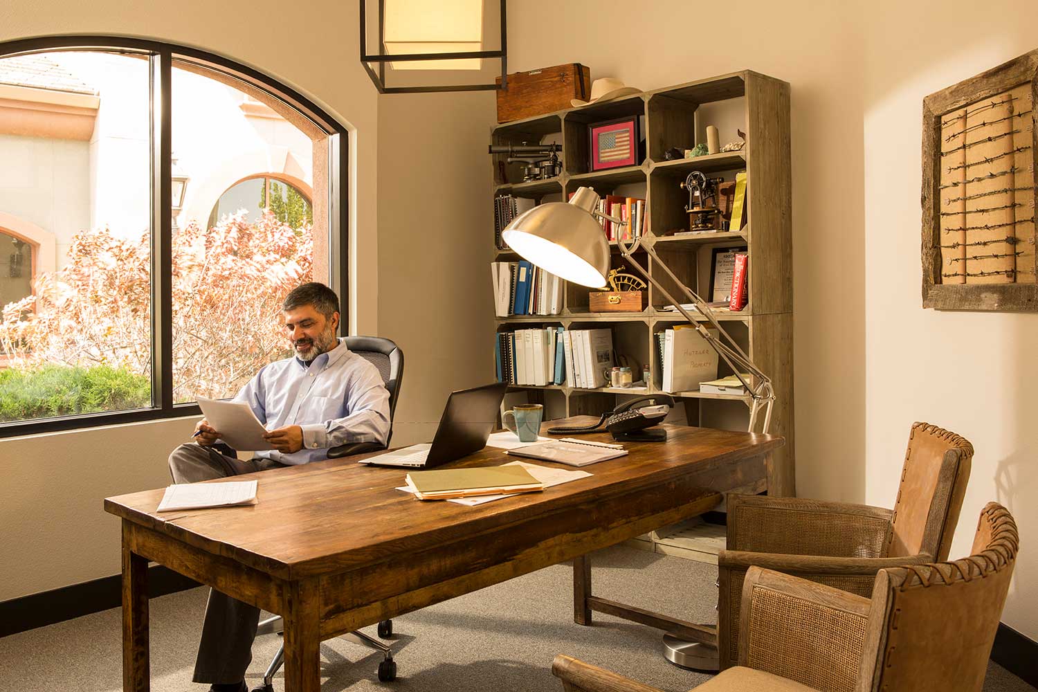 Man looks at file behind desk