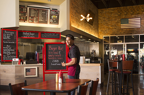 Employee writes on chalk board in restaurant