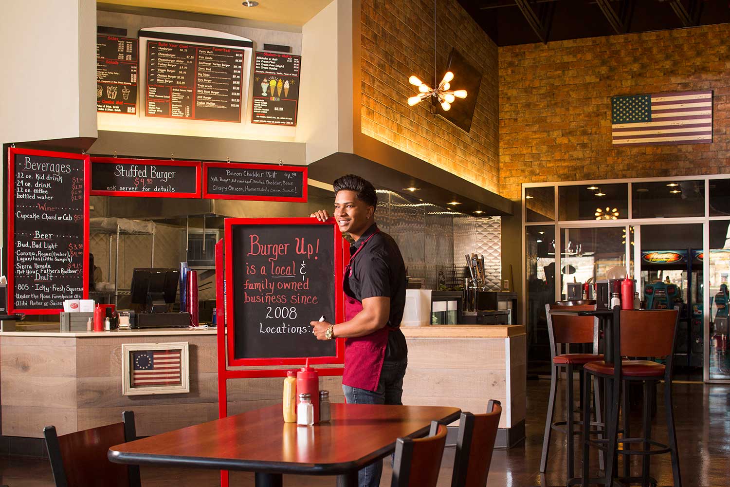 Employee writes on chalk board in restaurant