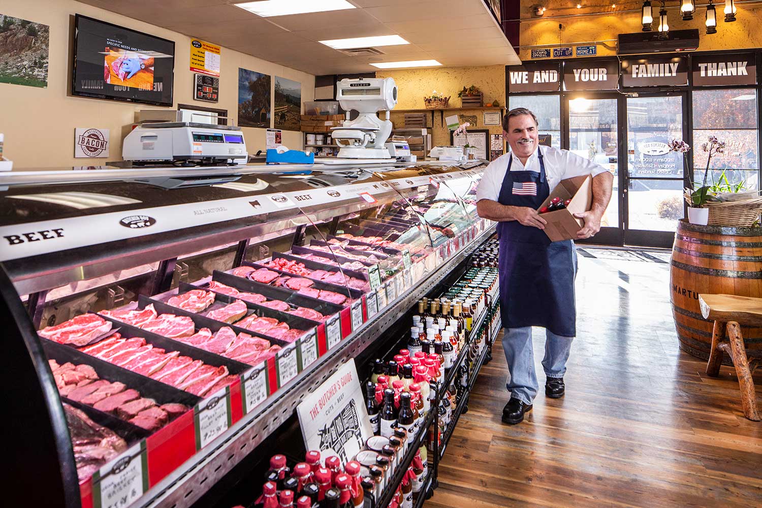 Man carries a box through a butcher shop