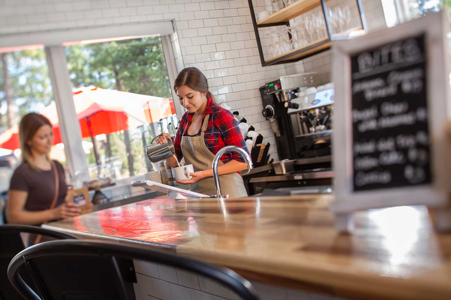 Coffee shop employee pours drink into cup