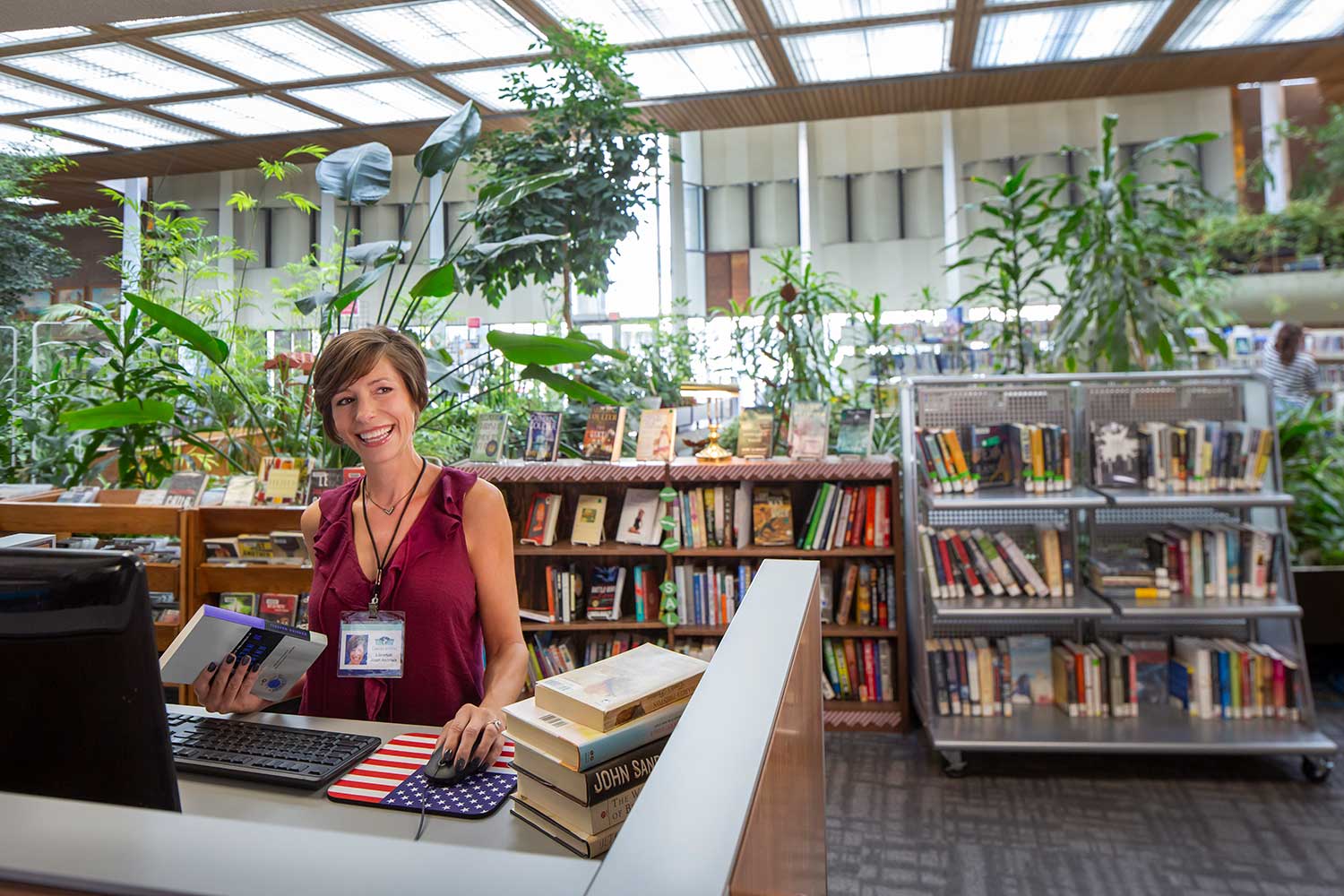 Librarian scans books behind a desk