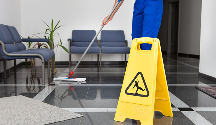Employee cleaning up spill in office building