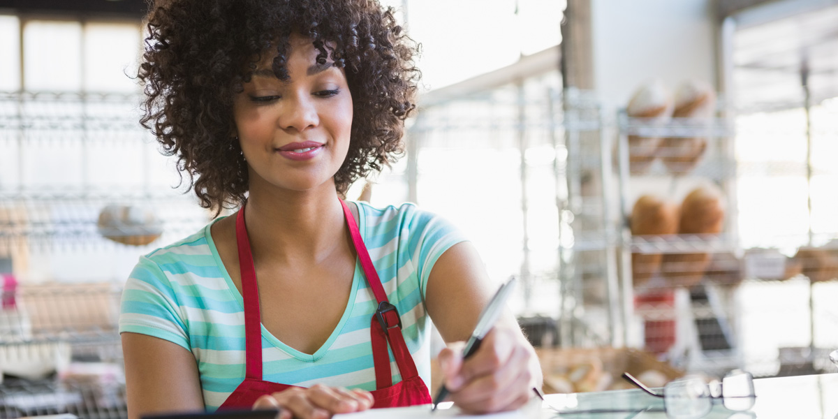 Women writing at bakery counter