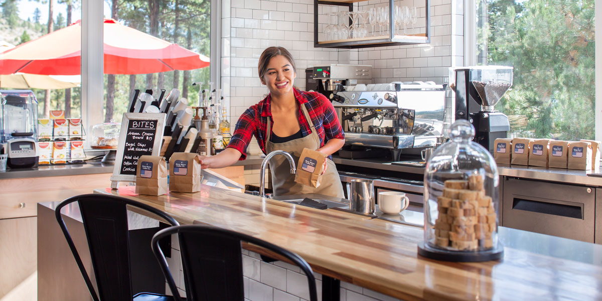 Worker at coffee shop setting out a bag